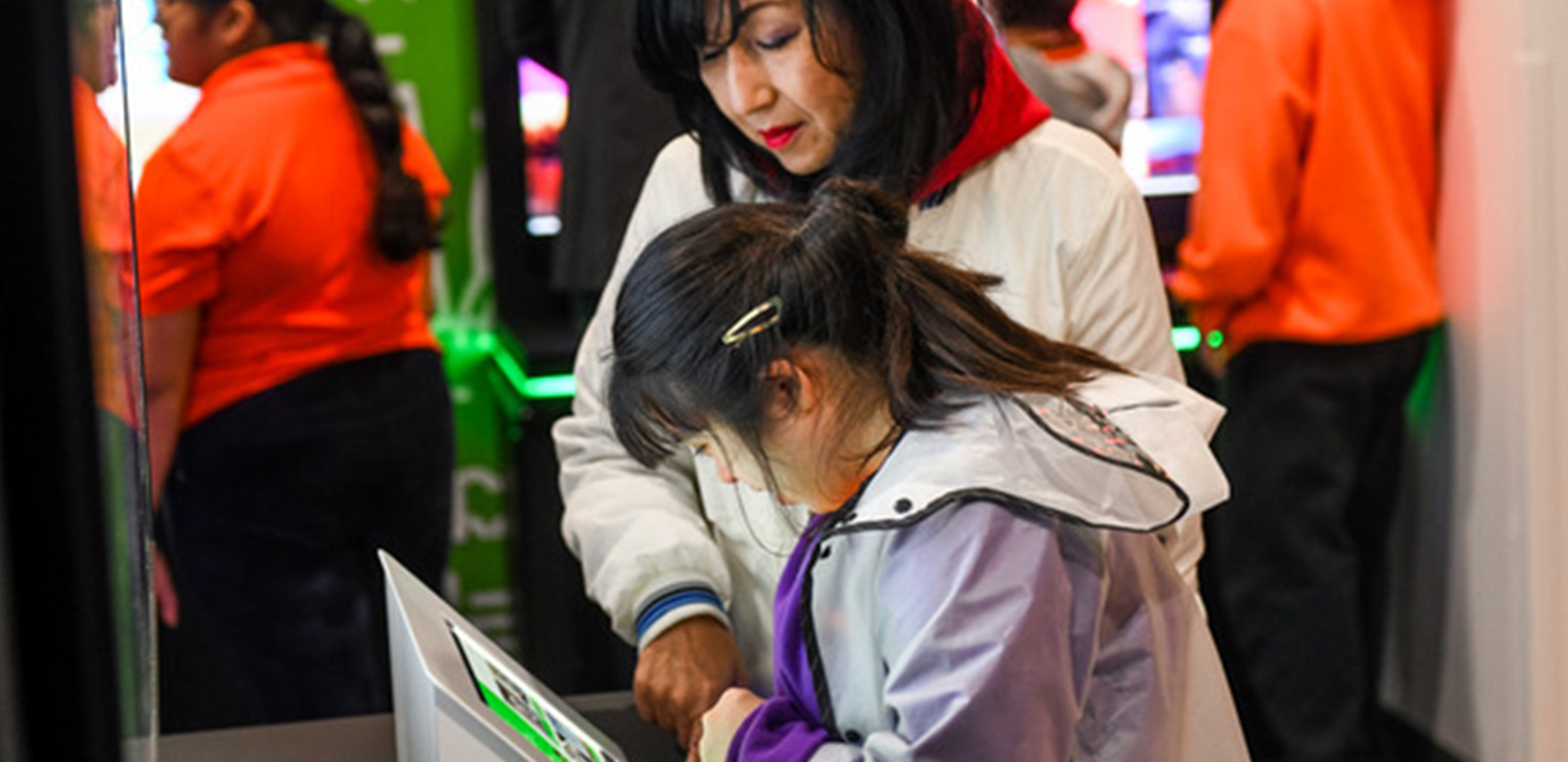 A woman and a young girl in front of a Surface screen