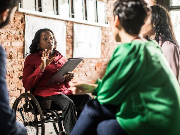 Businesswoman in wheelchair leading group discussion