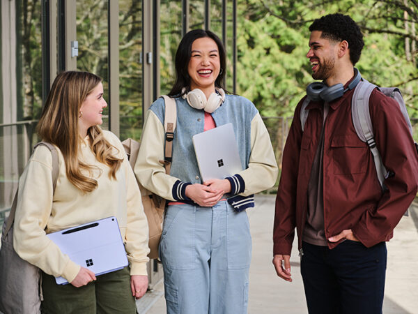 Three students chatting outside of a building.
