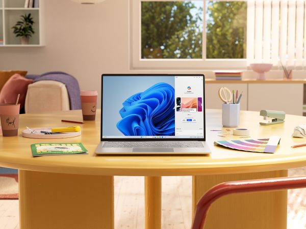 Laptop running Microsoft Copilot on a living room table along with creative tools