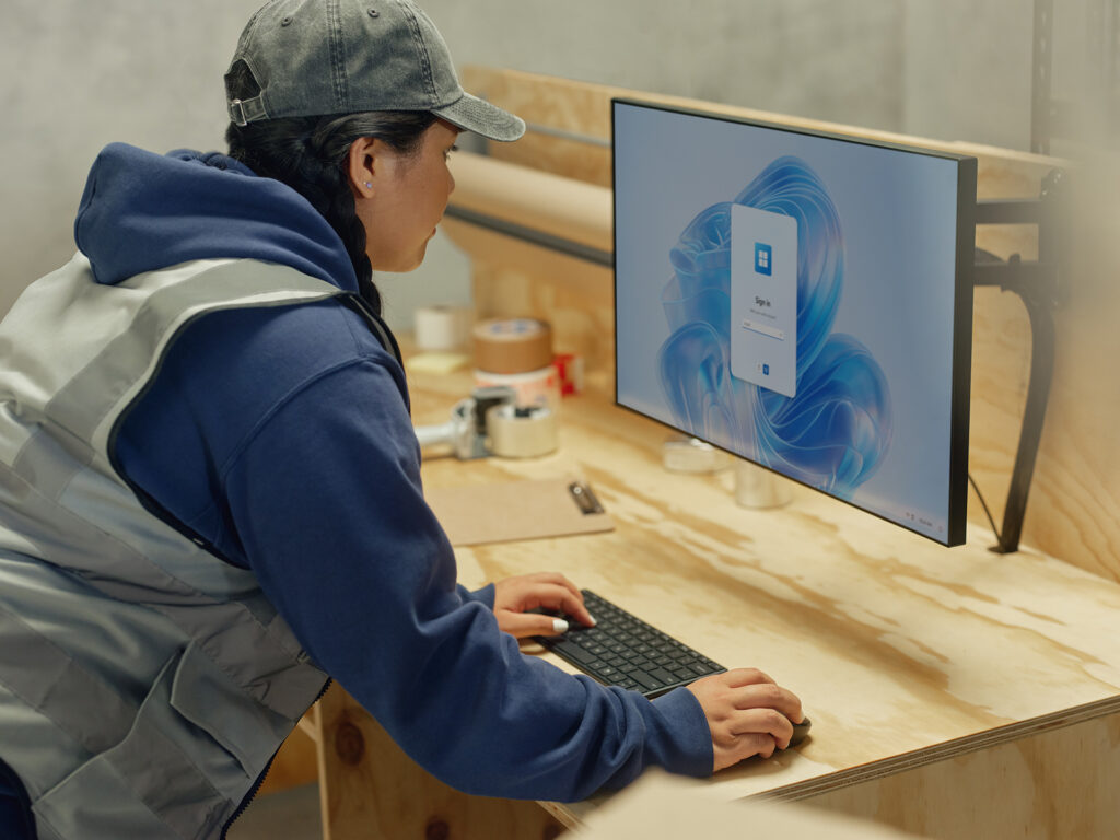 Woman working at a computer station in a warehouse.