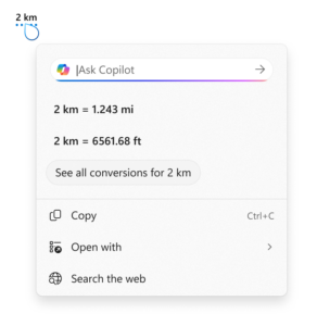 Screenshot showing the conversion tool for Click to Do using the example of 2 kilometers. It displays conversions to miles (1.243 mi) and feet (6561.68 ft), with options to copy, open with, or search the web.